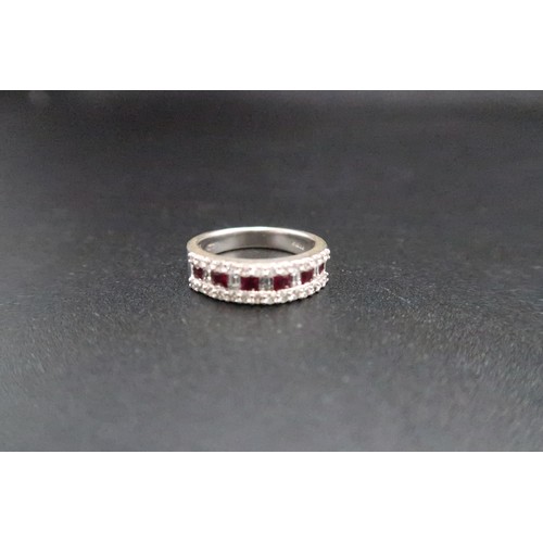 221 - An 18ct white gold (hallmarked) diamond and red stone (believed to be ruby) half eternity ring - the... 