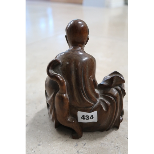  A Japanese hardwood carved figure sat with a tiger and a book, signed to the base, 18cm high.