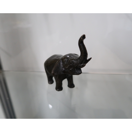  A bronze figure of an elephant with trunk uplifted, 11cm high.