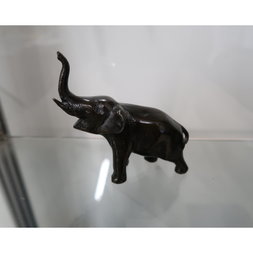  A bronze figure of an elephant with trunk uplifted, 11cm high.