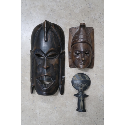  An East African carved wood mask, 32 by 16cm, together with a small fertility figure and a wall mask... 