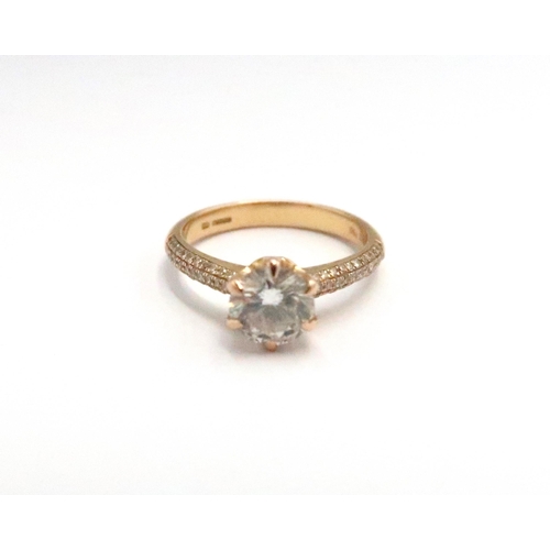  An 18ct gold brilliant cut diamond ring with three rows of diamonds to each shoulder. Accompanied by... 