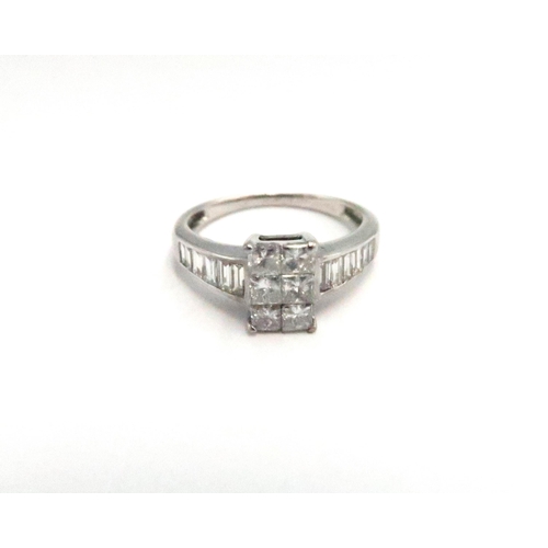 8 - An 18ct diamond dress ring, designed as six tension set princess cut diamonds, with graduating bague... 