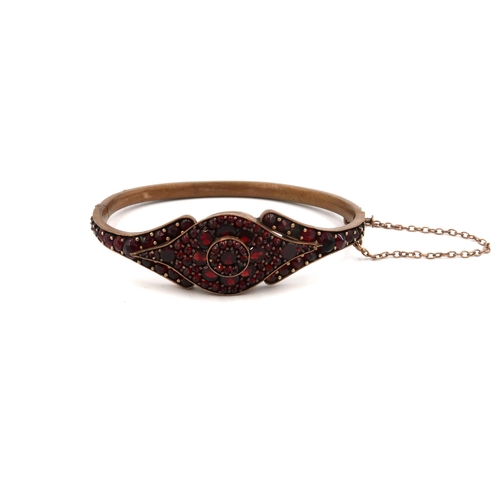 114 - A 19th century garnet set bangle, on rolled gold, internal diameter, 49 by 61.6mm, 17.1g total weigh... 