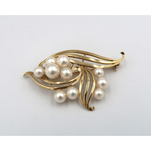 123 - An openwork cultured pearl broch. Width 57mm. Stamped K 14. Weight 10.67 grams