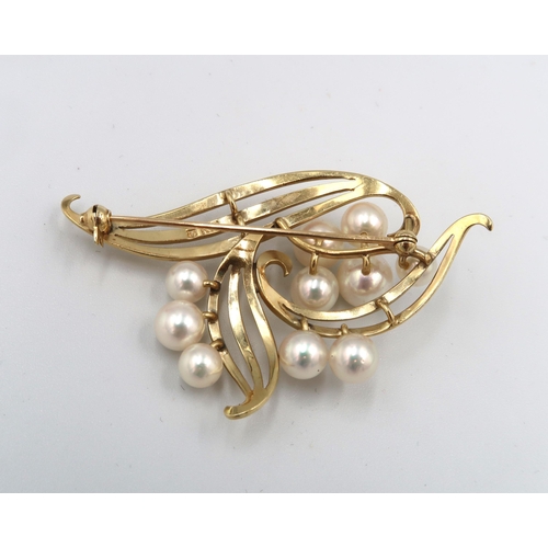 123 - An openwork cultured pearl broch. Width 57mm. Stamped K 14. Weight 10.67 grams