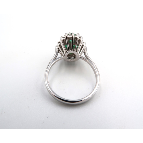 150 - An emerald and diamond dress ring, the central emerald quatrafoil cluster surrounded by diamond bril... 