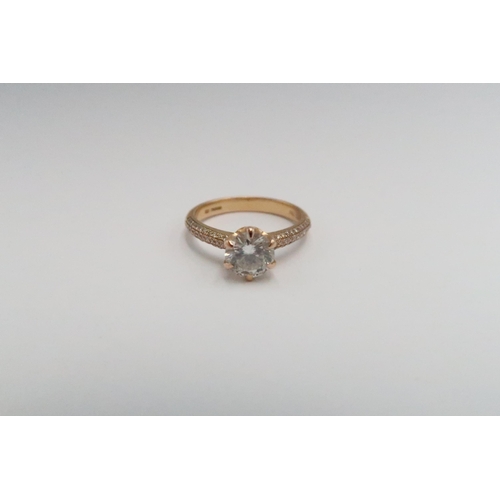 5 - An 18ct gold brilliant cut diamond ring with three rows of diamonds to each shoulder. Accompanied by... 