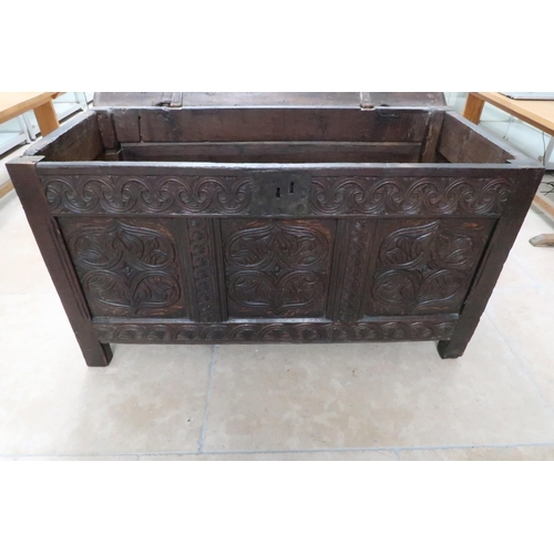 674 - A heavily carved three panel oak coffer - Height 61cm x Width 111cm x Depth 53cm