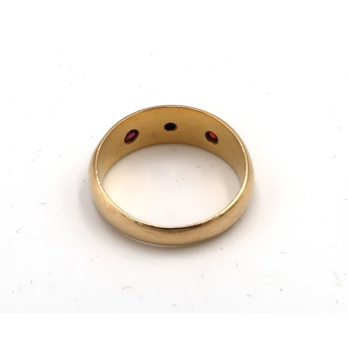  An 18ct gold diamond and red stone gypsy set three stone ring. Size K. Weight 2.01 grams