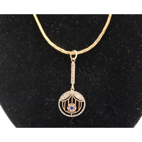  A 9ct gold chain suspending an open work single stone sapphire pendant. Tests 9ct. Weight 7.07 grams