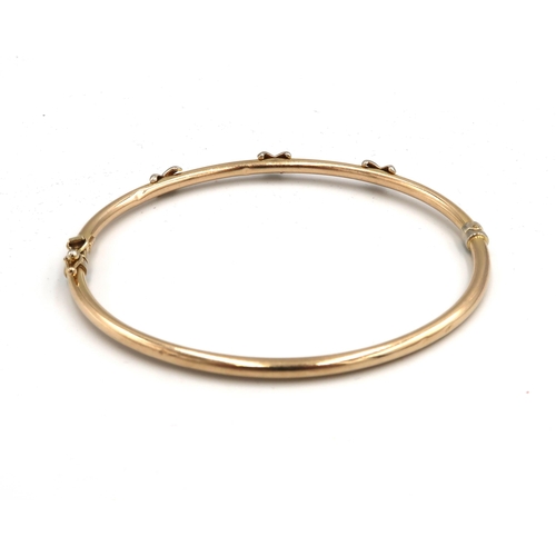 24 - A bi colour hinged bangle with cross detail. Stamped 375. Weight 4.25 grams