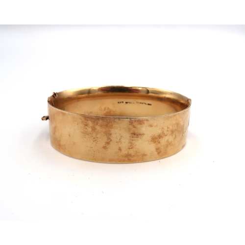 66 - A 9ct gold and solid metal core, Victorian style bangle, hinged with two panels, one foliate engrave... 