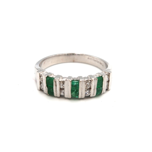 85 - An 18ct white gold, emerald and diamond half eternity, seven stone ring of mid century brutalist sty... 