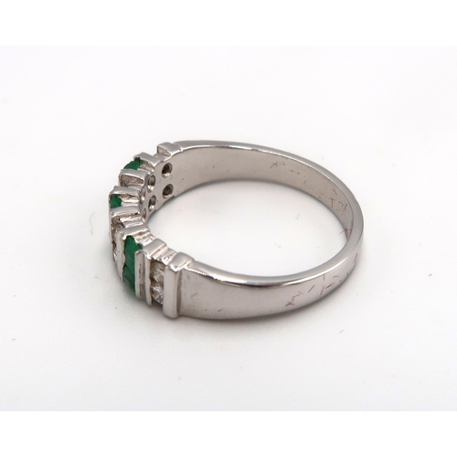 85 - An 18ct white gold, emerald and diamond half eternity, seven stone ring of mid century brutalist sty... 