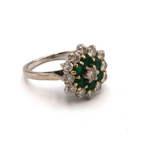 87 - A vintage 18ct white gold, emerald and diamond flowerhead ring, set with central diamond surrounded ... 