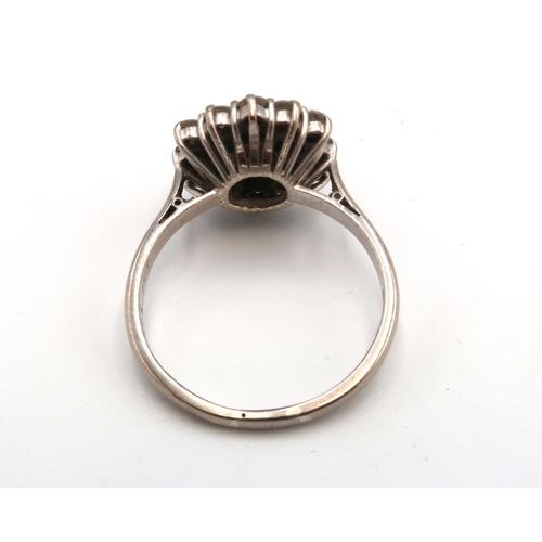 87 - A vintage 18ct white gold, emerald and diamond flowerhead ring, set with central diamond surrounded ... 
