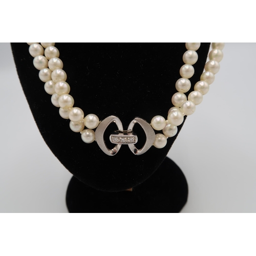 90 - A double row choker of pearls, with 18ct white told clasp set with three diamonds, and two restraini... 