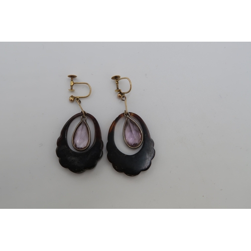 112 - A pair of tortoiseshell earrings with pear shape amethyst central drops. Stamped 9ct. Weight 5.38 gr... 