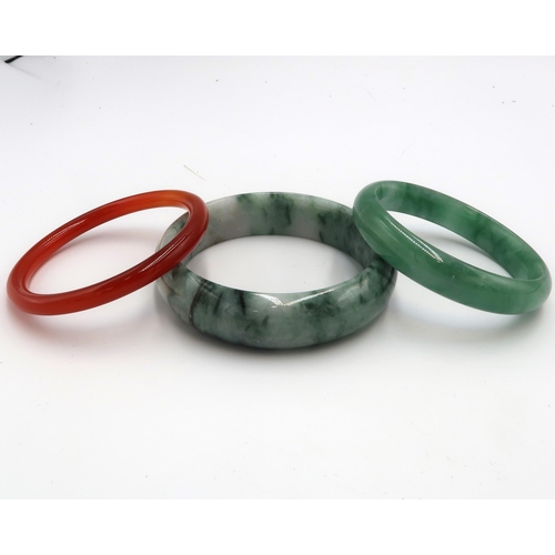 114 - Three bangles believed to be jade and nephrite. Untested for natural colour origin. Weight 154.10 gr... 