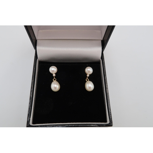 144 - A pair of 14ct gold, diamond and pearl drop earrings, each set with teardrop shaped pearl suspended ... 