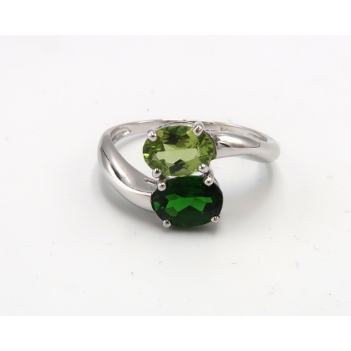 152 - A 9ct white gold and green stone crossover ring, likely peridot and tsavorite, size U, 3.9g.