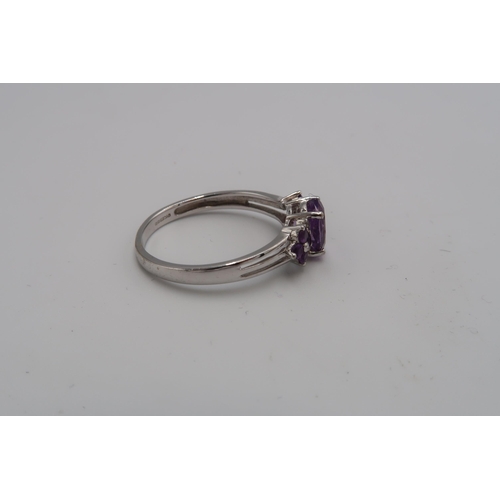 153 - A 9ct white gold, diamond and lilac stone dress ring, the central oval cut pale amethyst coloured st... 