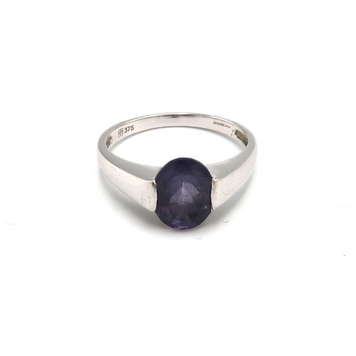 154 - A 9ct white gold and deep amethyst coloured solitaire ring, the oval stone of approximately 10.0 by ... 