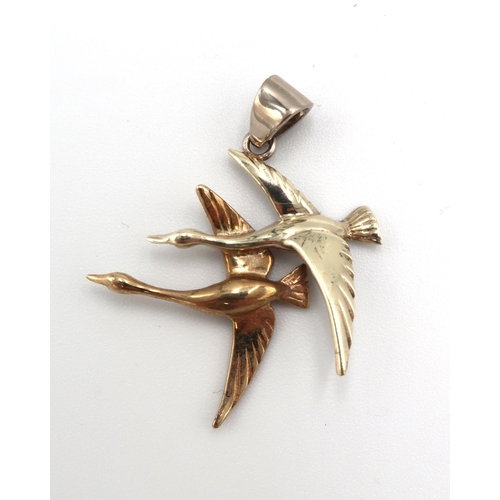 158 - A 9ct bi-colour gold pendant modelled as two swans in flight, 2.6g.