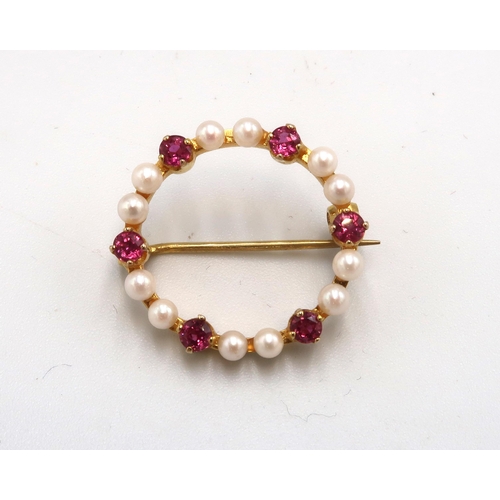 165 - A 9ct gold, seed pearl and ruby circular brooch, set with six rubies, intersperced with a pair of se... 