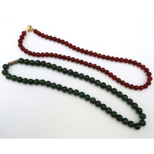 223 - A nephrite jade bead necklace Weight 41.47 grams. Together with a brown bead necklace. Weight 22.57 ... 