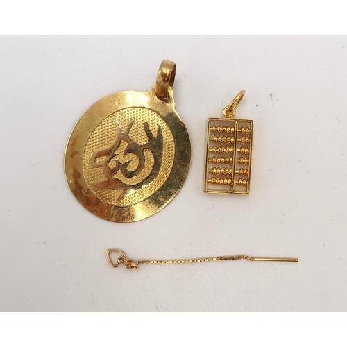 224 - An oval pendant with oriental symbol. Together with an abacus charm. Both test 18ct gold. Total weig... 