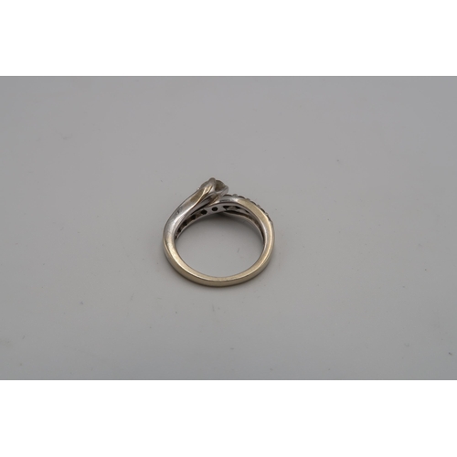 230 - An 18ct gold diamond crossover dress ring. Central diamond estimated 0.50ct. Estimated I/J colour. I... 