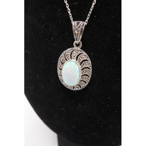 236 - An opal pendant, the oval opal of approximately 12 by 8mm in open backed silver setting with marcasi... 