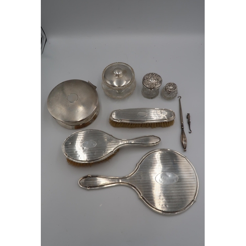 351 - A silver backed dressing table vanity set, comprising hairbrush, clothes brush and mirror, with engi... 