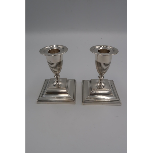 352 - A pair of silver candlesticks, of classical urn form on stepped square bases, Horace Woodward & Co L... 