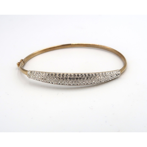 55 - A 9ct gold bangle, set with white stones, 5.87 by 5.17cm internal diameter, 3.4g.