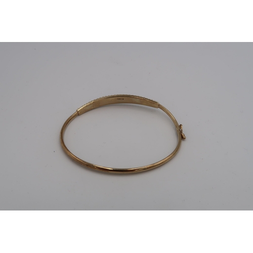 55 - A 9ct gold bangle, set with white stones, 5.87 by 5.17cm internal diameter, 3.4g.