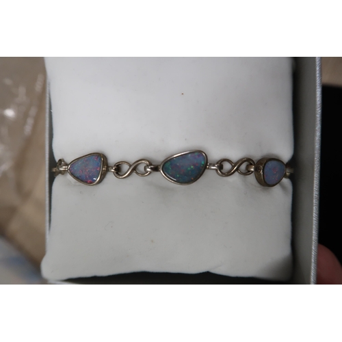 88 - A silver, cubic zirconia and blue stone set dress ring, size T, a silver and opal panelled bracelet,... 