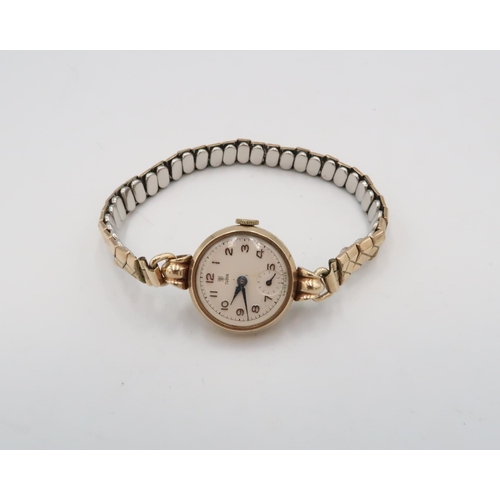 303 - A mid 20th Tudor watch. Tests 9ct. On a metal expandable bracelet. Weight 19.16 grams
