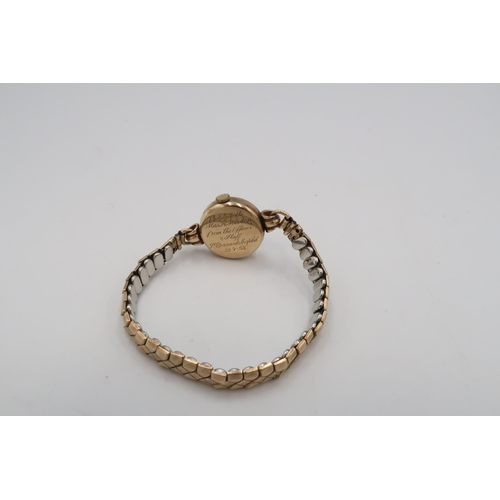 303 - A mid 20th Tudor watch. Tests 9ct. On a metal expandable bracelet. Weight 19.16 grams