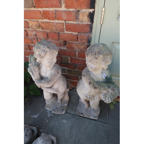 686 - A pair of cherub garden statues - 80cm - damage to the plinth on one of them