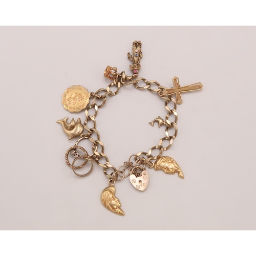 89 - A 9ct yellow gold charm bracelet with nine charms - approx weight 22.56 grams