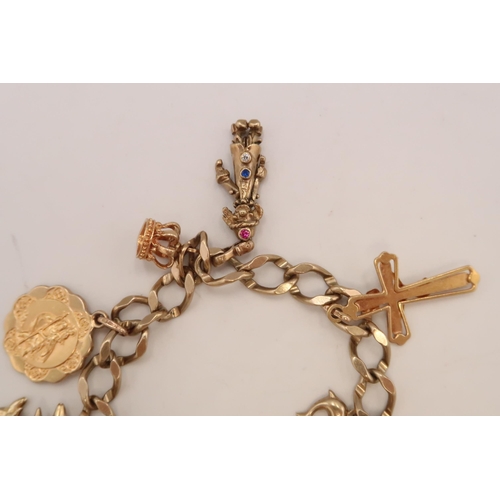 89 - A 9ct yellow gold charm bracelet with nine charms - approx weight 22.56 grams