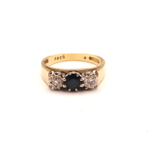 118 - An 18ct gold, sapphire and diamond three stone ring, the central dark blue sapphire of approximately... 