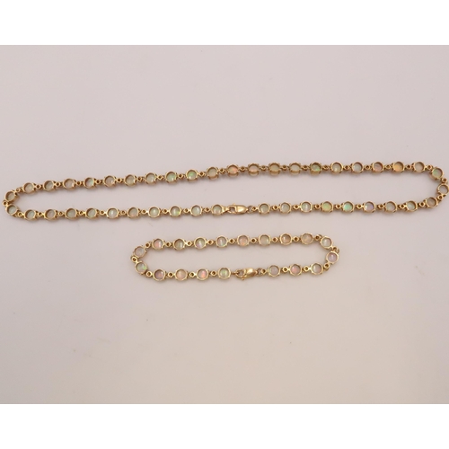 90 - An 18ct gold and Australian opal suite of jewellery comprising necklace and bracelet set with fourty... 