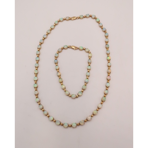 90 - An 18ct gold and Australian opal suite of jewellery comprising necklace and bracelet set with fourty... 
