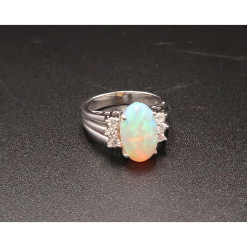 93 - An 18ct white gold, diamond and opal dress ring, the opal from Coober Pedy, Australia, with good mov... 