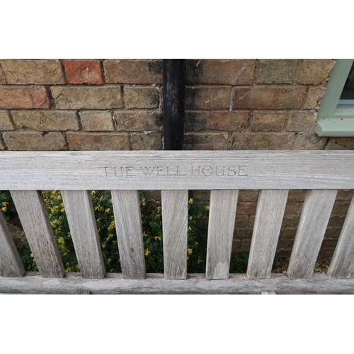 601A - A very good quality teak weathered bench inscribed The Well House - 182cm/6ft wide - in sound condit... 