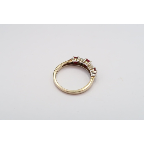 18 - A 9ct gold three stone ruby ring with diamond highlights. Size N 1/2. Weight 2.83 grams